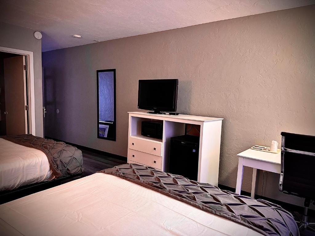 海恩尼斯Heritage House Inn的一间酒店客房,配有一张床和一台电视,还有一间客房