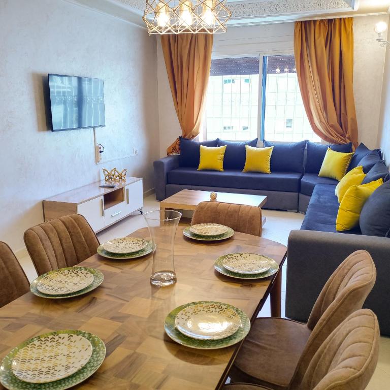 丹吉尔Beautiful Apartment in centre ville M2的客厅配有桌子和蓝色沙发