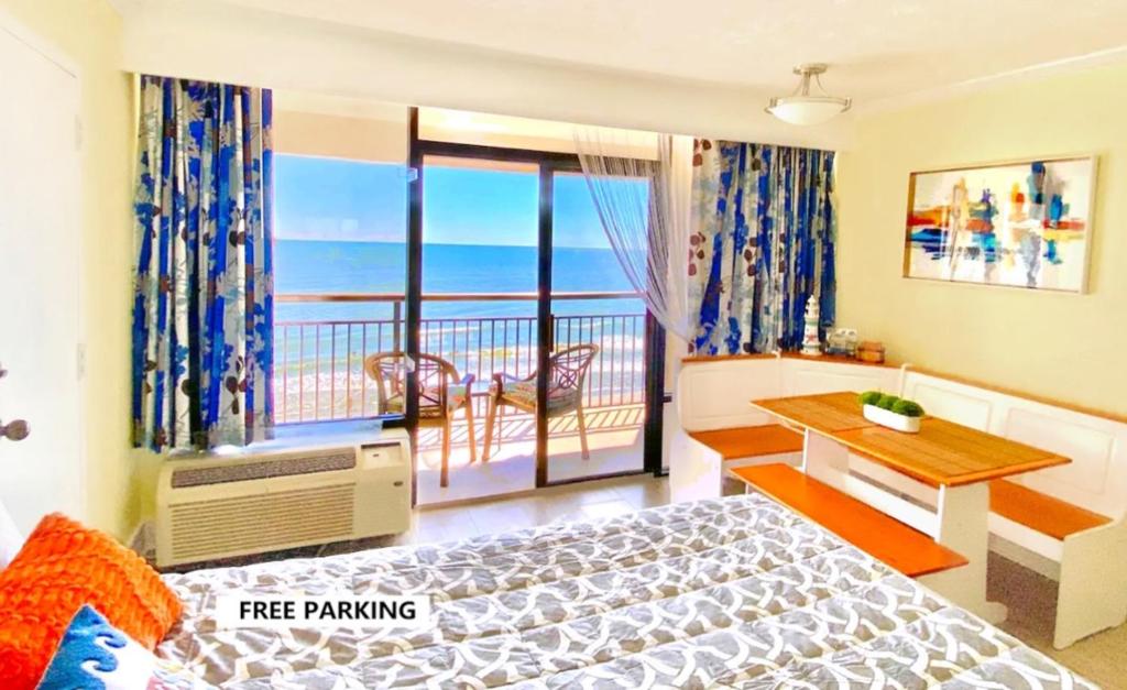 默特尔比奇Ocean Reef- Unique Oceanfront Condo-Free parking - Amazing pools的一间卧室设有一张床和一个海景阳台