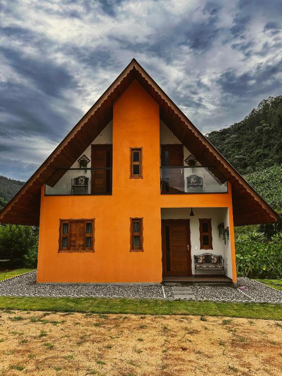 上大瓦尔任Chalé Casa em Vargem Alta的一座橙色的小房子