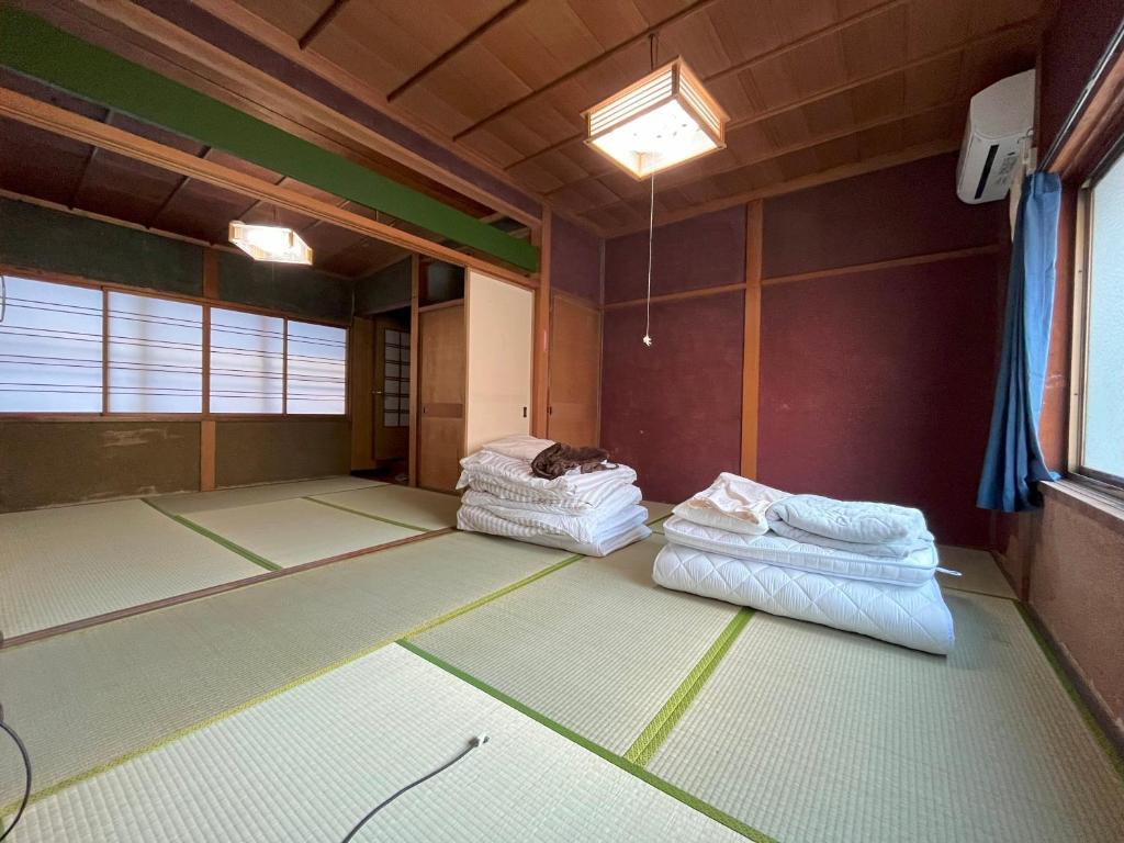 福井福井駅から徒歩2分の1棟貸切民泊 最低限的一间空房间,地板上配有两张床垫