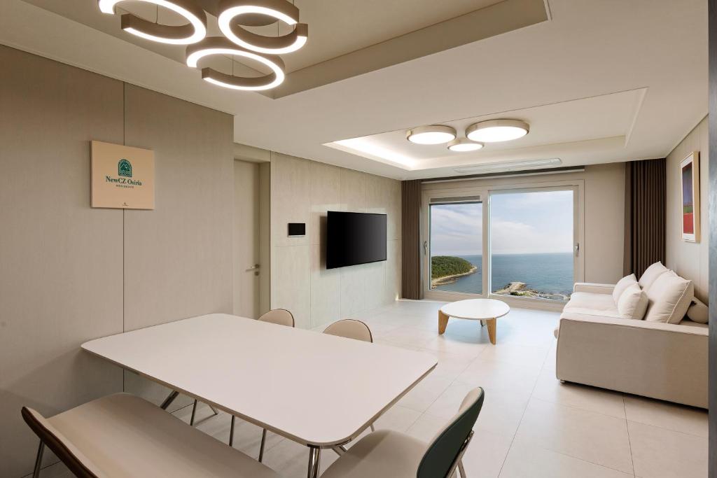 釜山NewCZ Osiria Residence的客厅配有白色的桌子和椅子