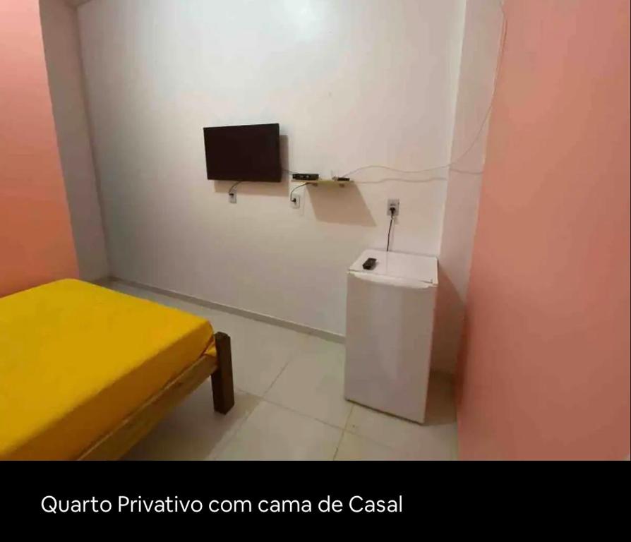 CaissaraHotel Divino的一间小房间,设有卫生间和墙上的电视