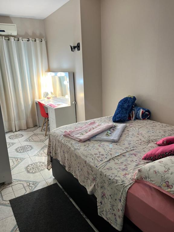 圣加布里埃尔Quarto em casa familiar的一间卧室配有一张带桌子和镜子的床