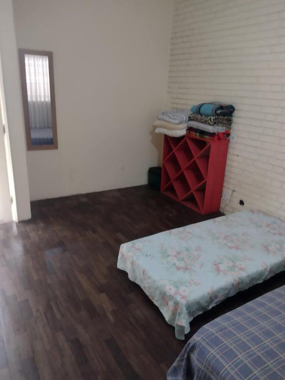 贝洛奥里藏特Hostel Aruanda的配有一张床和一张带床垫的桌子的房间