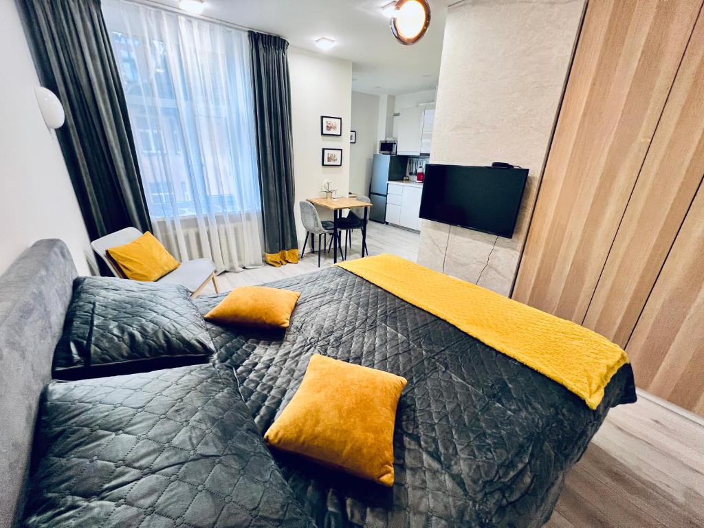 里加Cozy apartments的一间卧室配有一张带黄色枕头的床