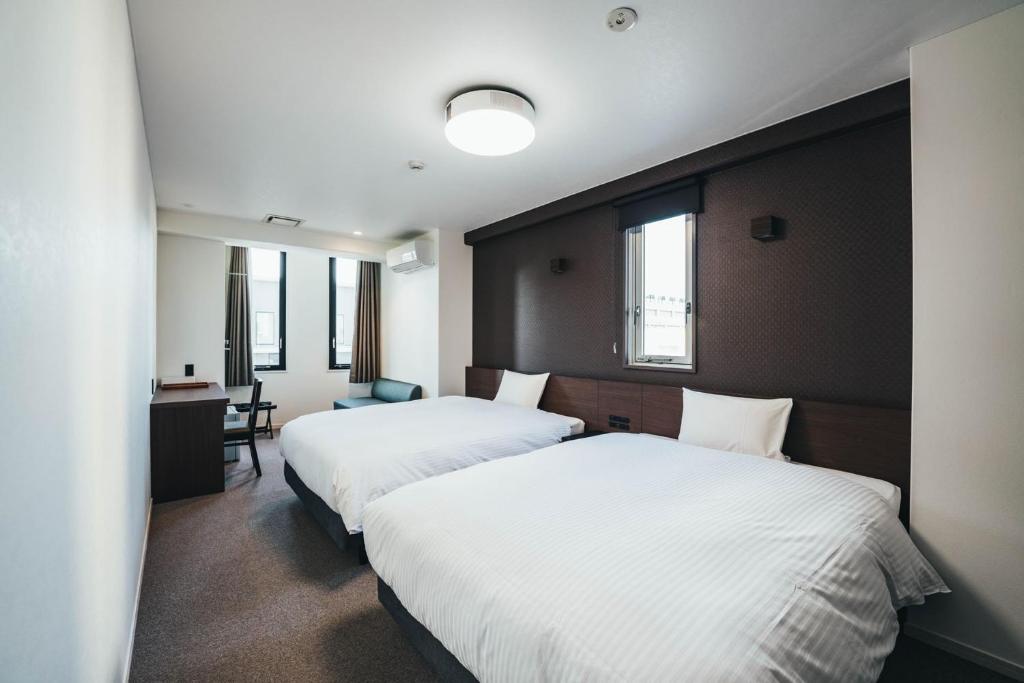 佐贺市TAPSTAY HOTEL - Vacation STAY 35239v的酒店客房配有两张床和一张书桌