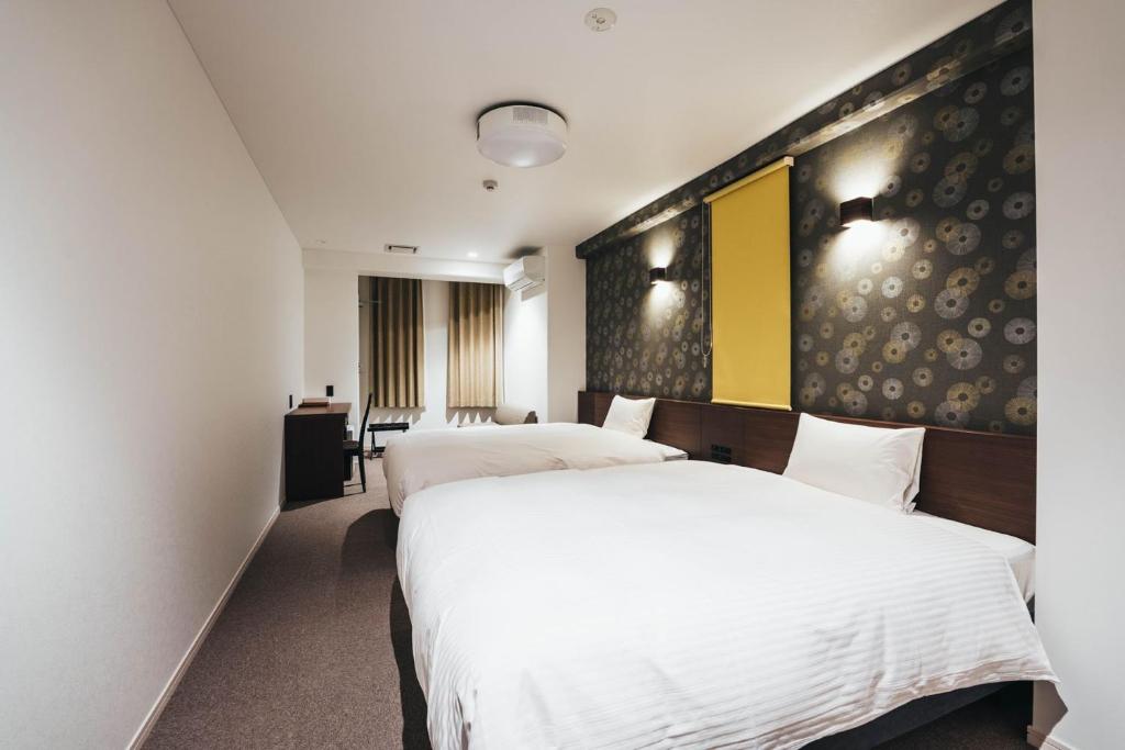 佐贺市TAPSTAY HOTEL - Vacation STAY 35232v的酒店客房配有两张床和一张书桌