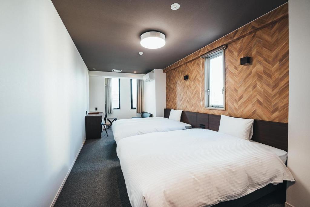 佐贺市TAPSTAY HOTEL - Vacation STAY 35237v的配有木墙和窗户的客房内的两张床