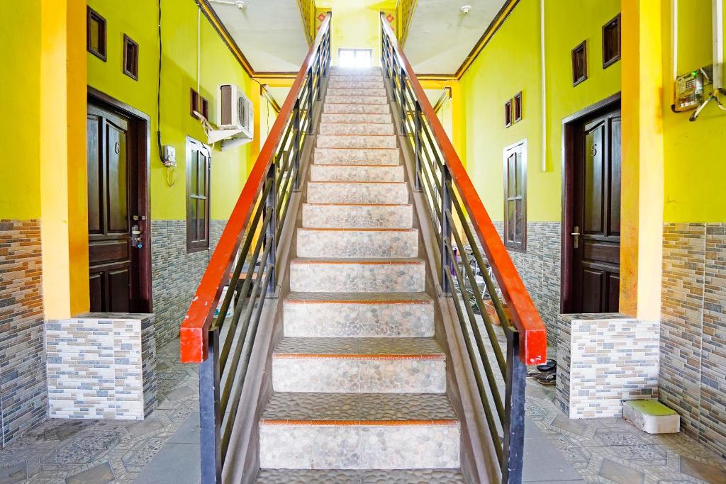 Tambak-kidulOYO 91583 D’cost Green Syariah的通往黄色墙壁的建筑的楼梯