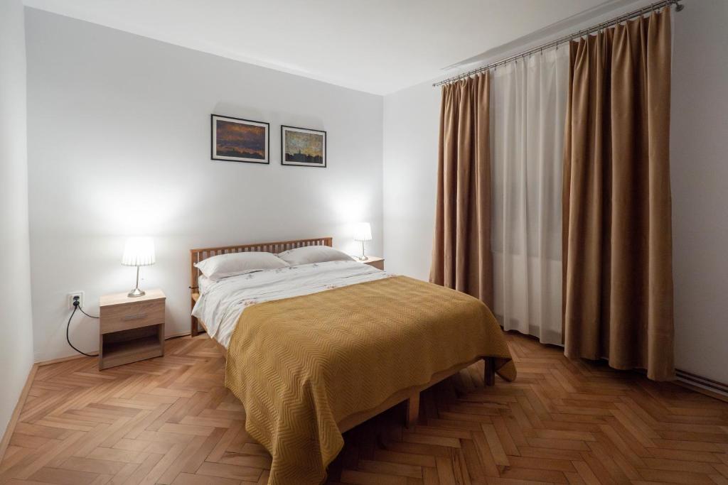 克卢日-纳波卡Casa Ryu的一间卧室配有一张床和一张带两盏灯的桌子。