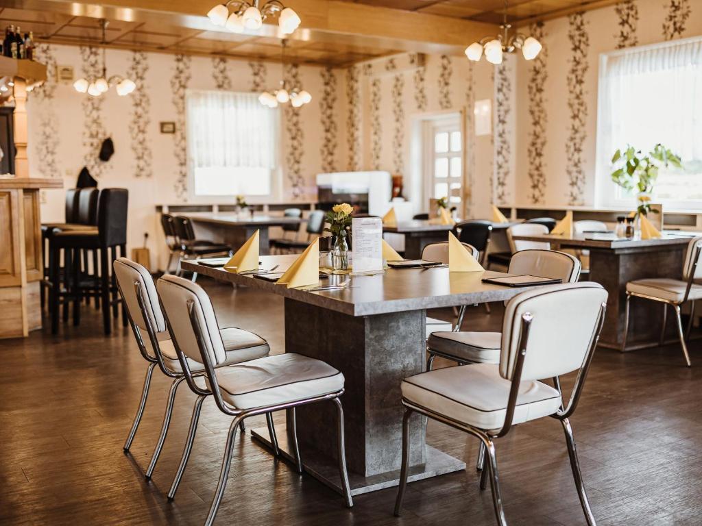 哈瑟尔费尔德REBENTISCH - HOTEL Ferienwohnungen Restaurant的餐厅设有酒吧,配有桌椅