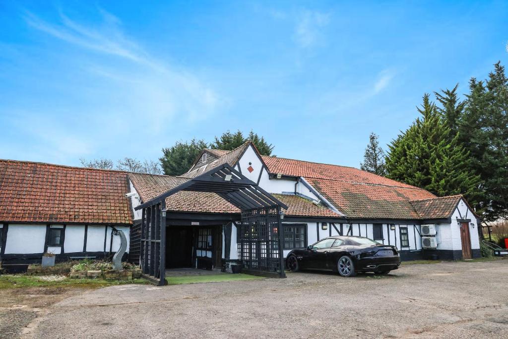 AstwickTudor Oaks Lodge Stevenage North的前面有停车位的房子