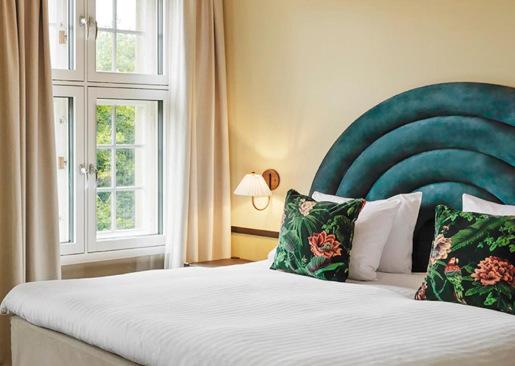 奥斯陆克里斯蒂提特酒店的一间卧室配有一张大床和绿色床头板
