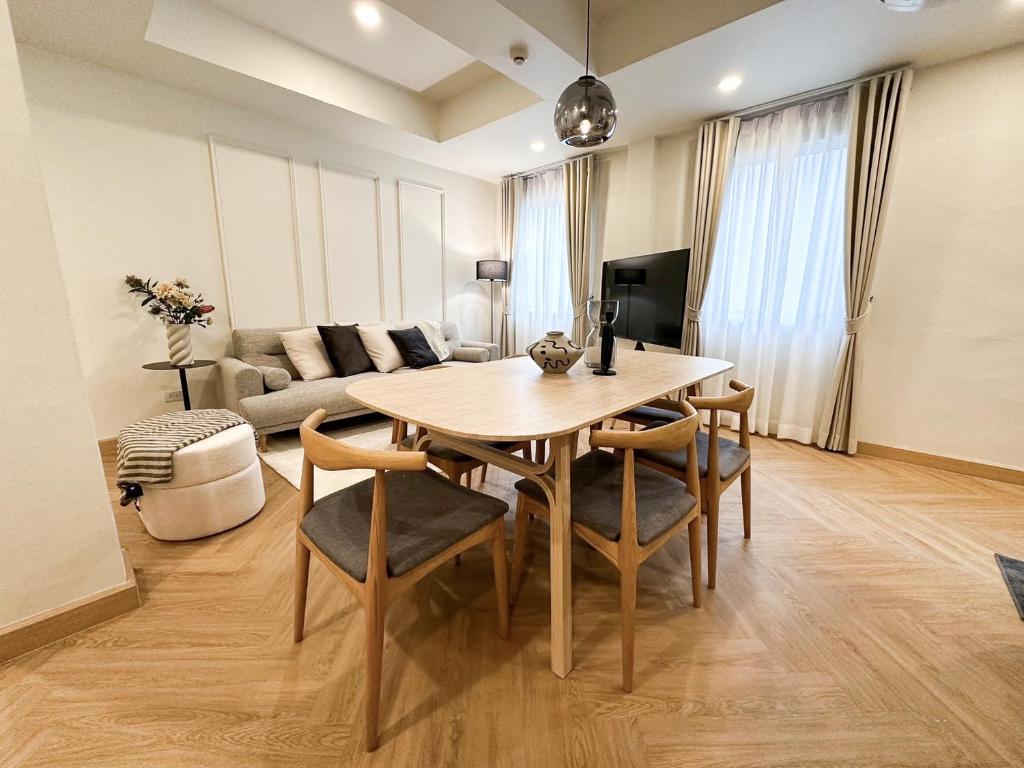 曼谷Upscale 3-bedroom 3-bathroom suite 1 min to BTS Prompong的客厅配有桌椅和沙发