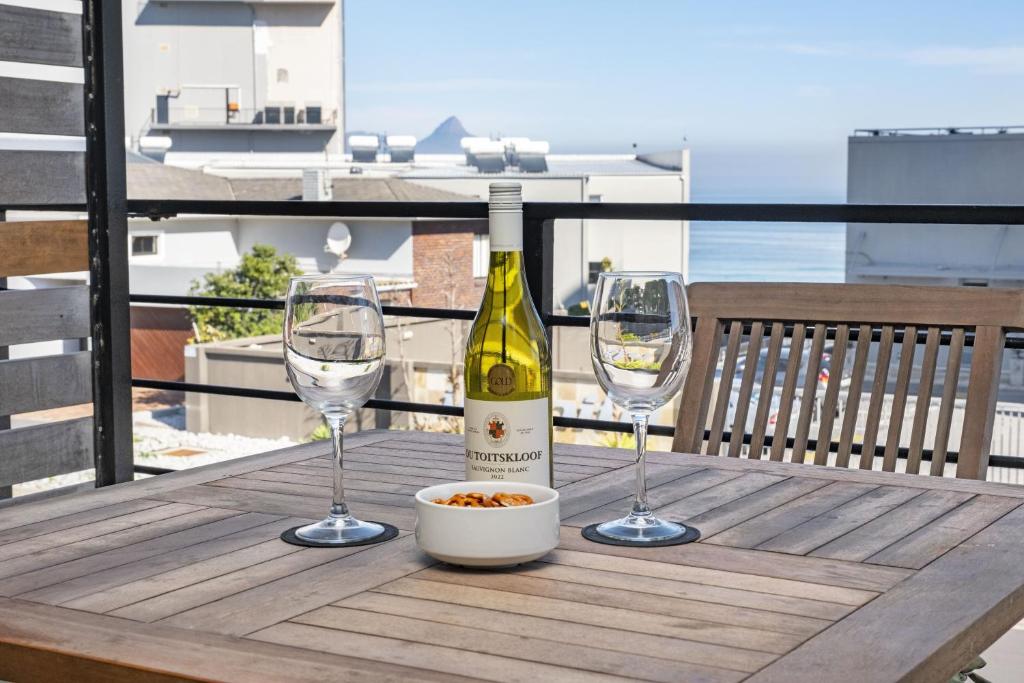 布鲁堡史特兰Manhattan on Coral 7的桌子上放有一瓶葡萄酒和两杯酒