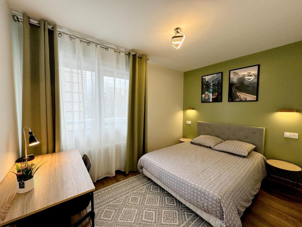 维勒班T2 Tête d’Or Confort + Parking gratuit的一间卧室配有一张床、一张书桌和一个窗户。