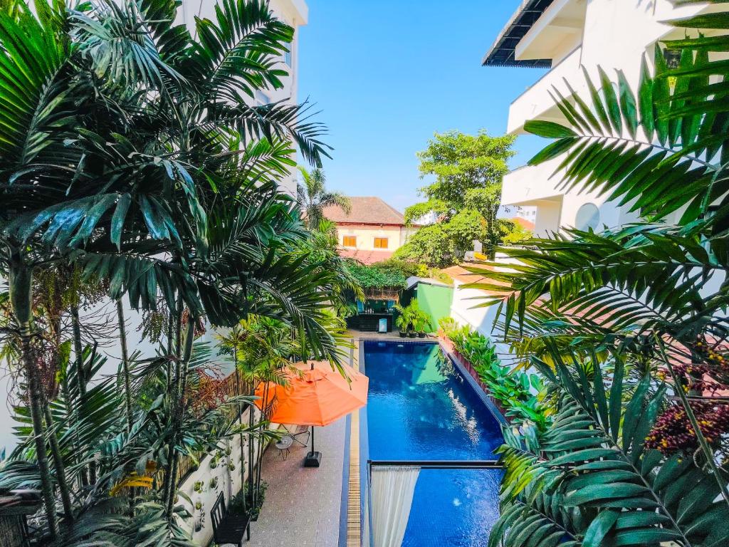 暹粒Siem Reap Urban Boutique Hotel的享有棕榈树建筑中游泳池的景色