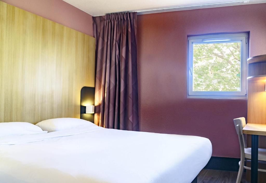 尼姆B&B HOTEL Nîmes Centre Arènes的一间卧室设有两张床和窗户。