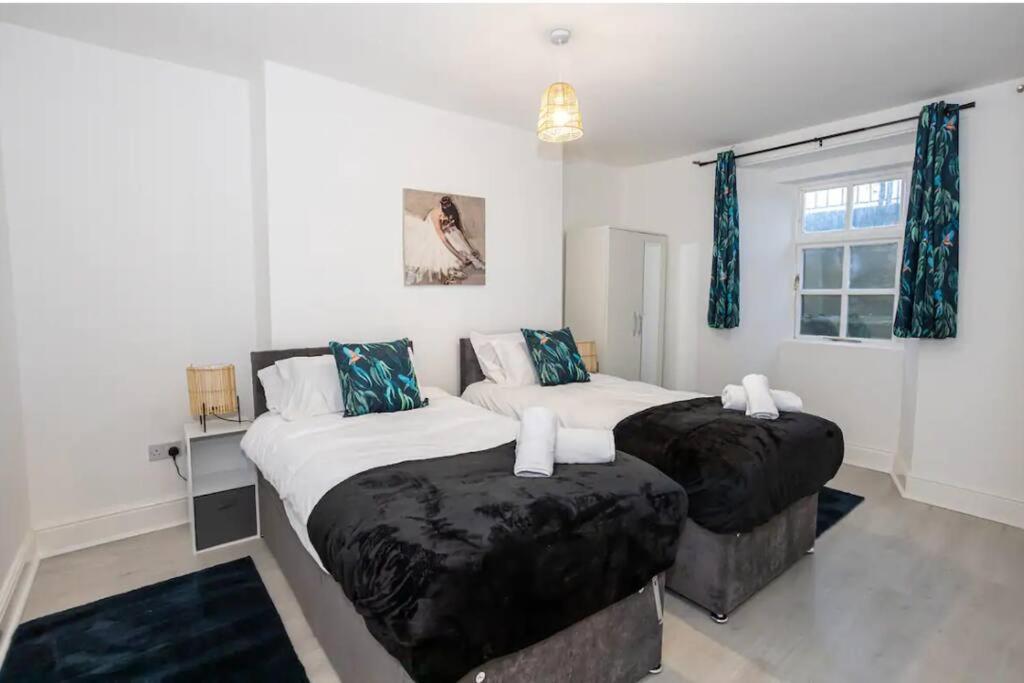 伯肯黑德Devonshire Road - Apartment 1的卧室设有两张单人床和蓝色窗帘