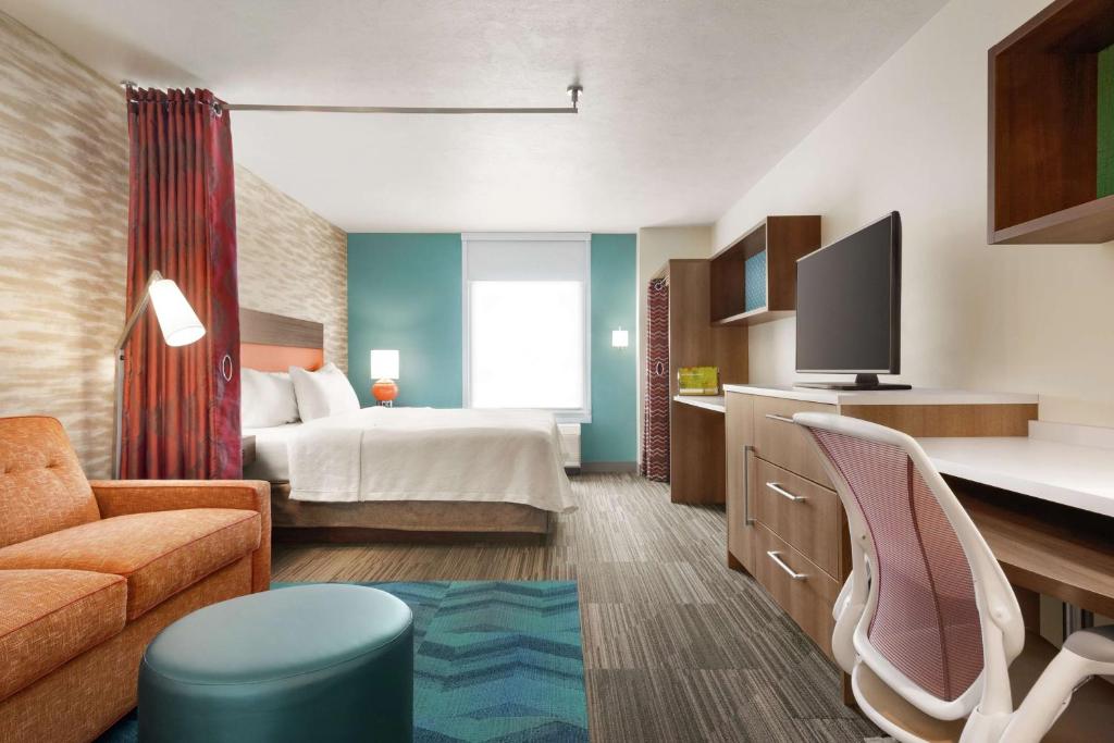 诺默尔Home2 Suites By Hilton Bloomington Normal的酒店客房,配有床和沙发