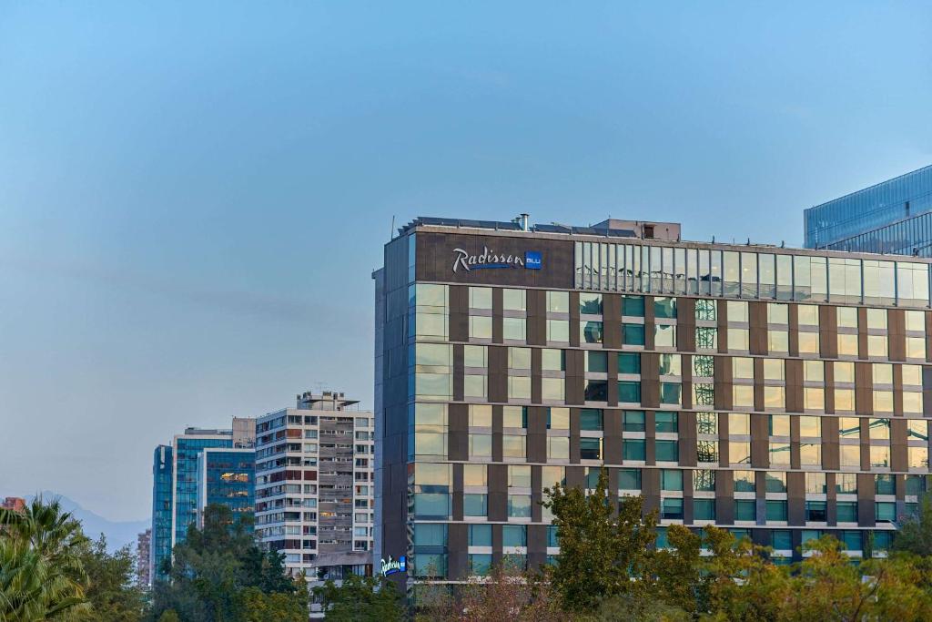 圣地亚哥Radisson Blu Plaza El Bosque Santiago的一座高大的建筑,上面有标志