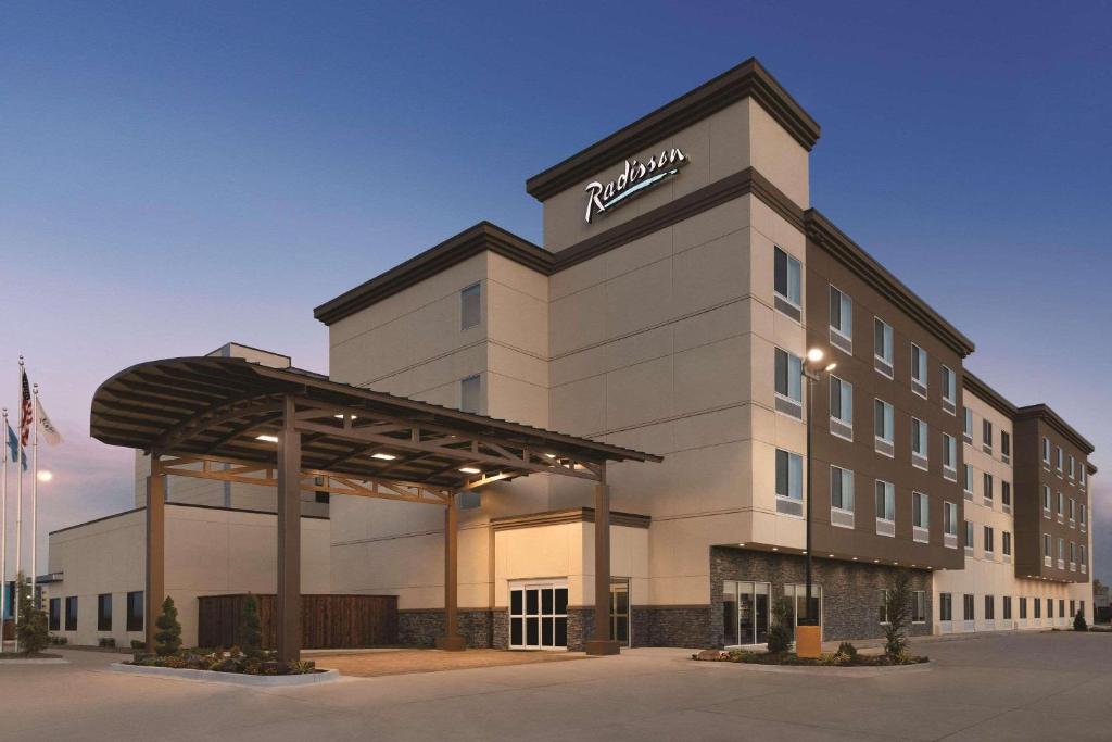 俄克拉何马城Radisson Hotel Oklahoma City Airport的上面有尼桑标志的酒店大楼