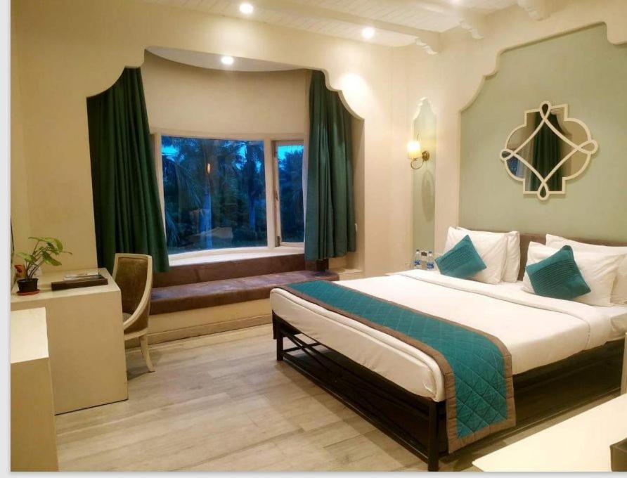 加尔各答Ibiza The Fern Resort & Spa, Kolkata的一间卧室设有一张大床和一个窗户。