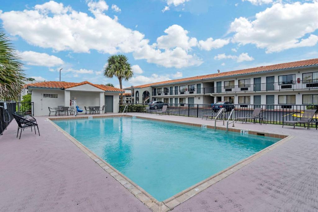 奥兰多Quality Inn & Suites Orlando East - UCF Area的大楼前的大型游泳池