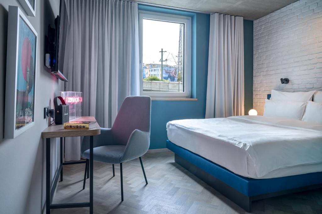 科隆URBAN LOFT Cologne的酒店客房,配有床、桌子和椅子