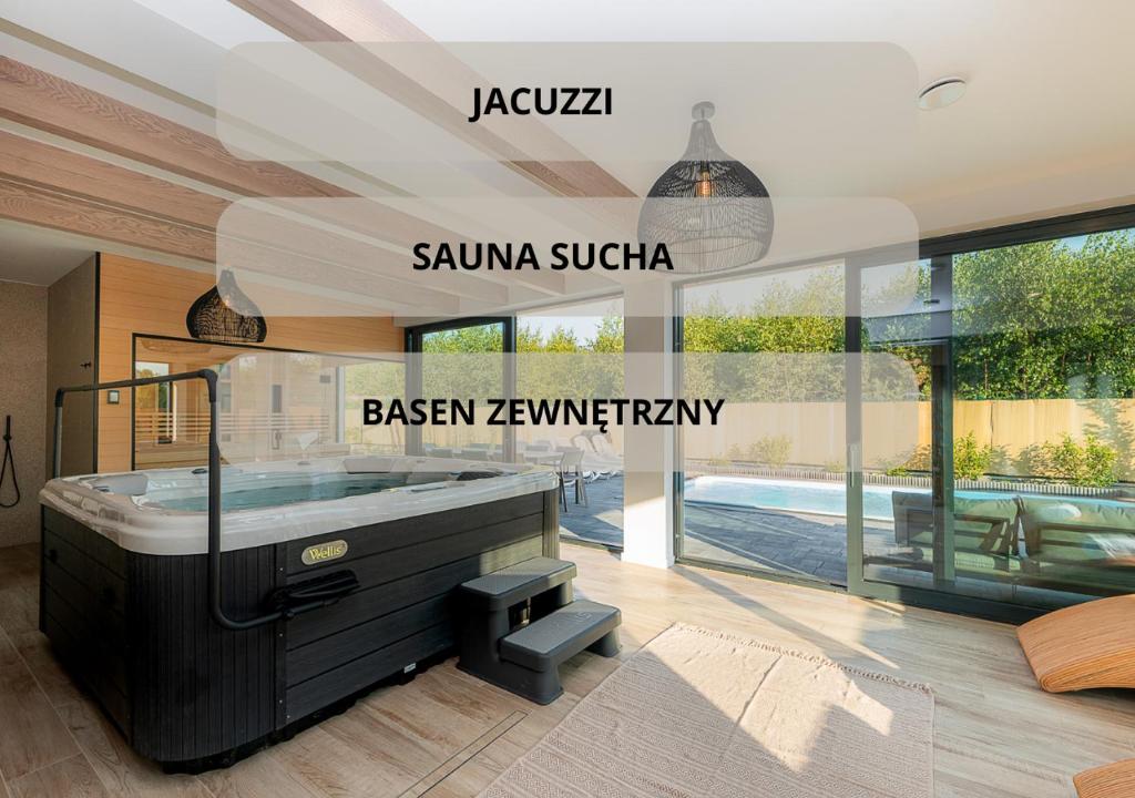 梅尔诺Mielnovo - dom z basenem, sauną i jacuzzi的玻璃客房内带大浴缸的浴室