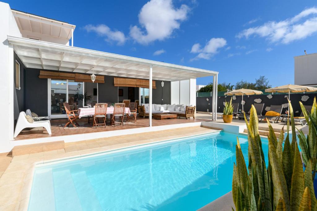 科斯塔特吉塞Villa Golf Lanzarote的一座带庭院的房屋前的游泳池
