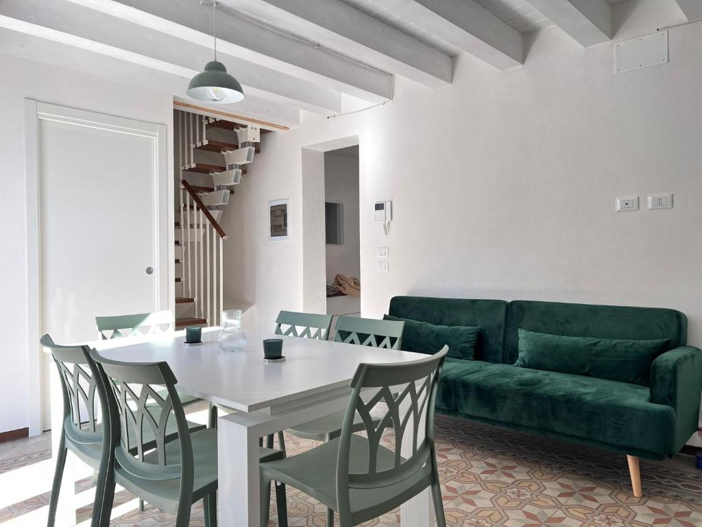 FicarazziM'AMA apartment的客厅配有绿色沙发、桌子和椅子