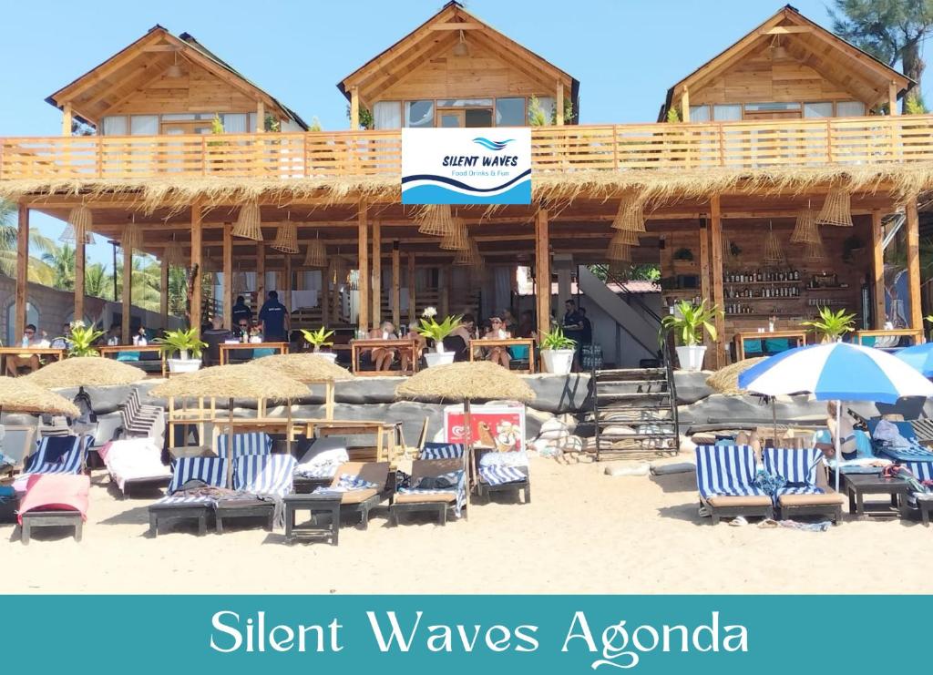 阿贡达Silent Waves的大楼前带椅子和遮阳伞的海滩