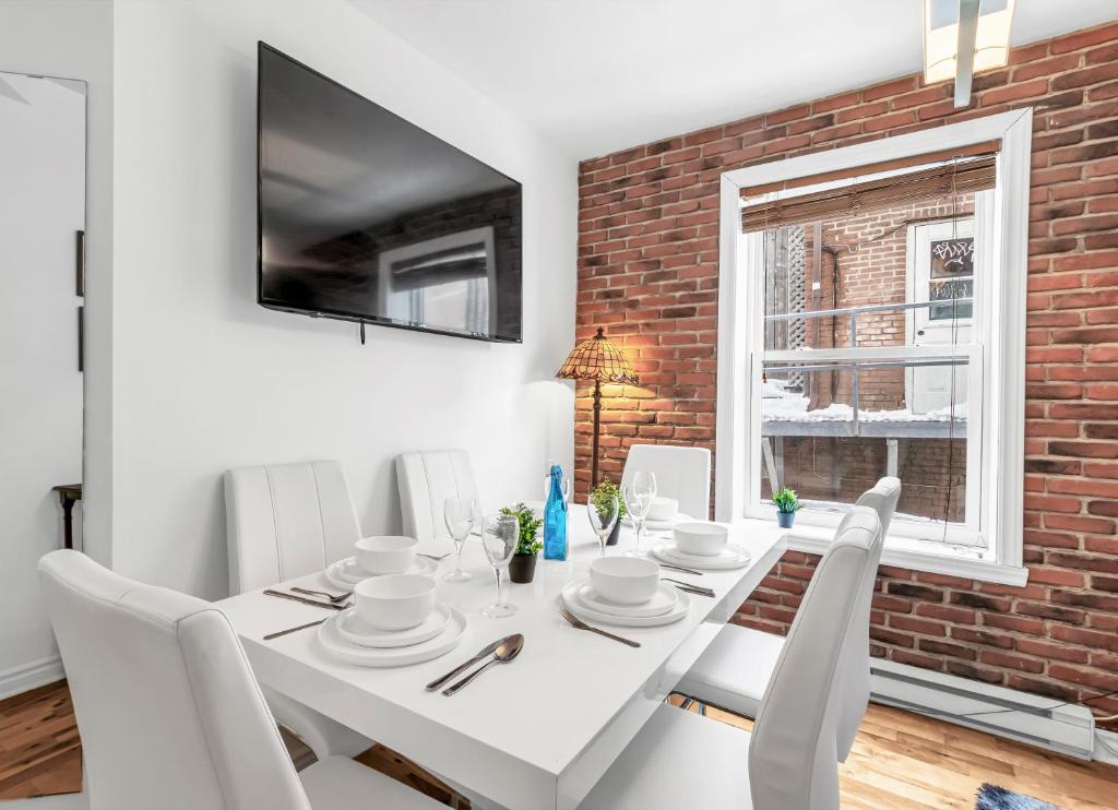 蒙特利尔DUPLEX FOR GROUP STAY_MONT-ROYAL的白色的用餐室配有白色的桌椅