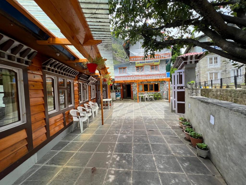 MonjoMount kailash lodge and resturant , Monjo的两栋带桌椅的建筑之间的走道