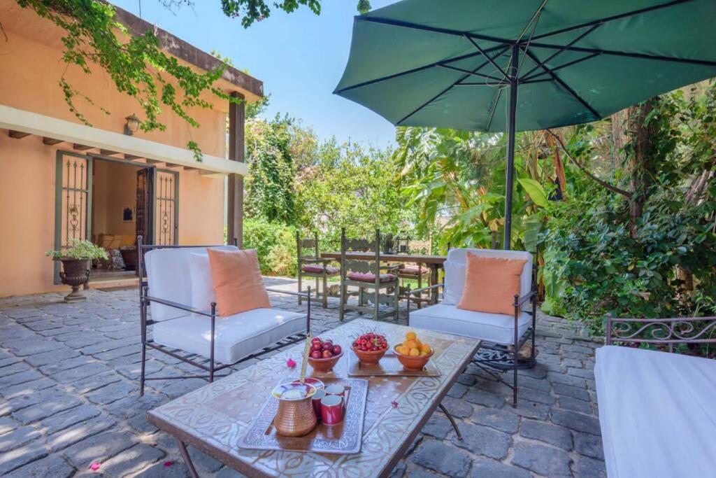 拜特龙La Madrague 3 Bedroom Villa with Garden in Batroun的庭院配有桌椅和遮阳伞。