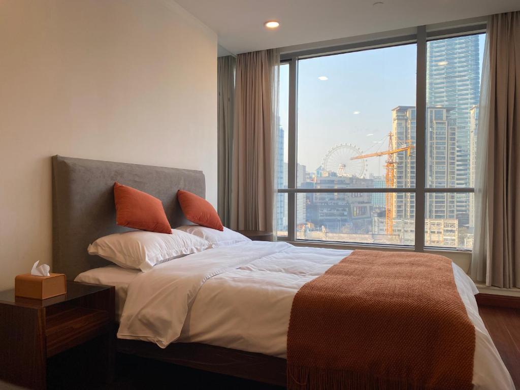 上海上海市中心怡水豪庭公寓的一间卧室设有一张床和一个大窗户