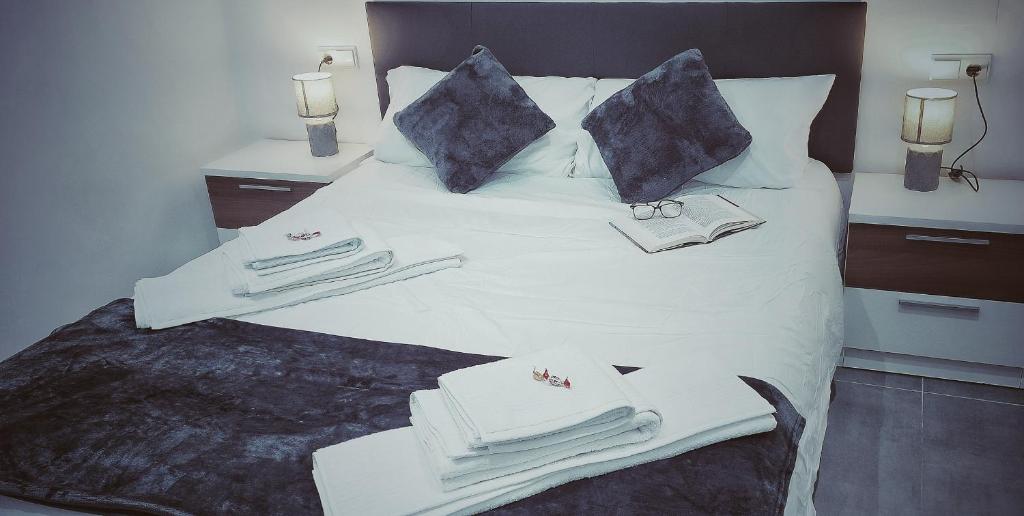 托雷利亚诺Apartamento La Paz的一张带毛巾和枕头的白色床