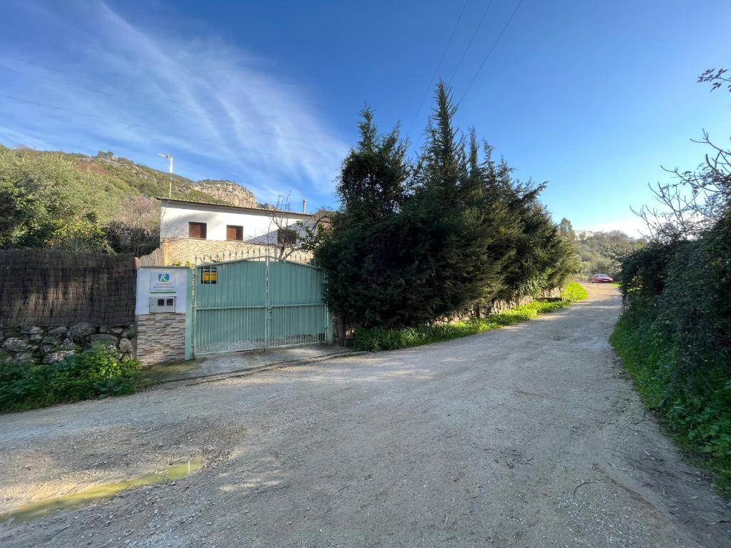 乌夫里克Casa rural Huertas de Ubrique的一条有绿色大门和房子的道路