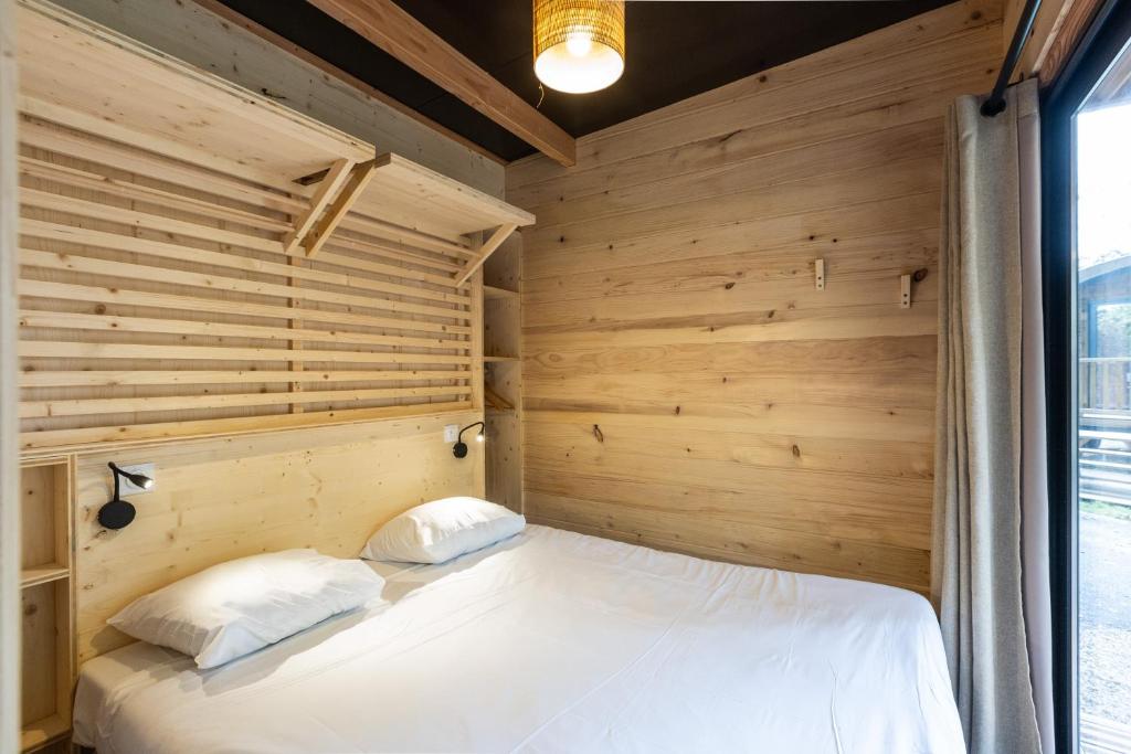 巴黎CityKamp Paris的一间卧室设有木墙和一张带两个枕头的床