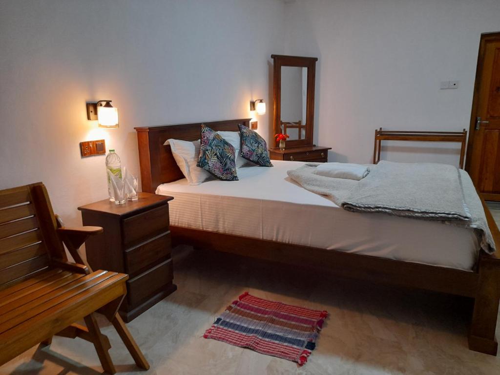哈普特莱Amaya View Guest Inn的一间卧室配有一张床、一把椅子和镜子