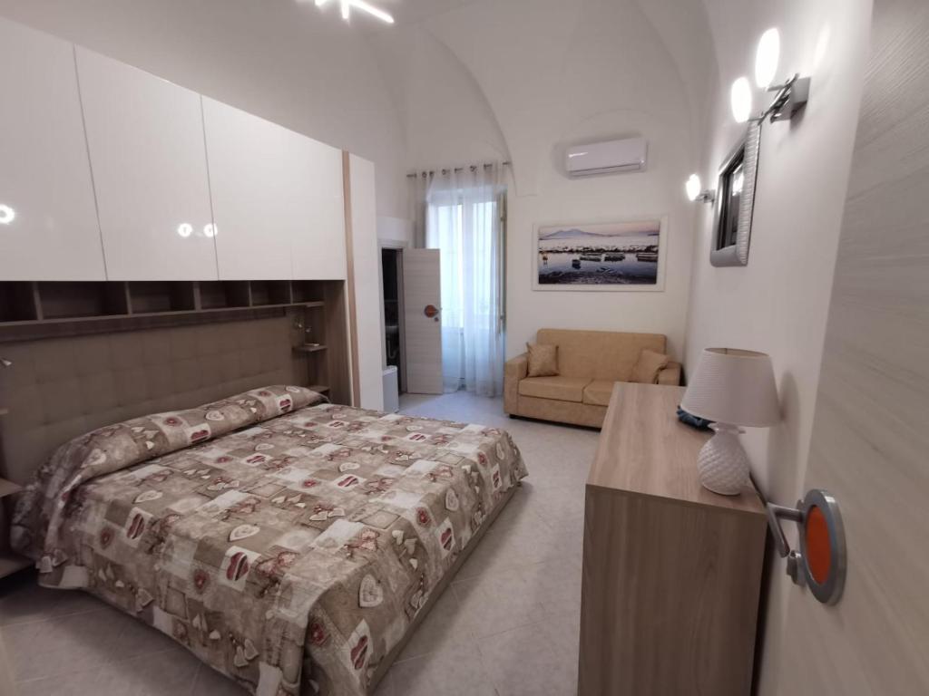 加埃塔La Pescheria Casa Vacanze的一间卧室配有一张床和一张沙发