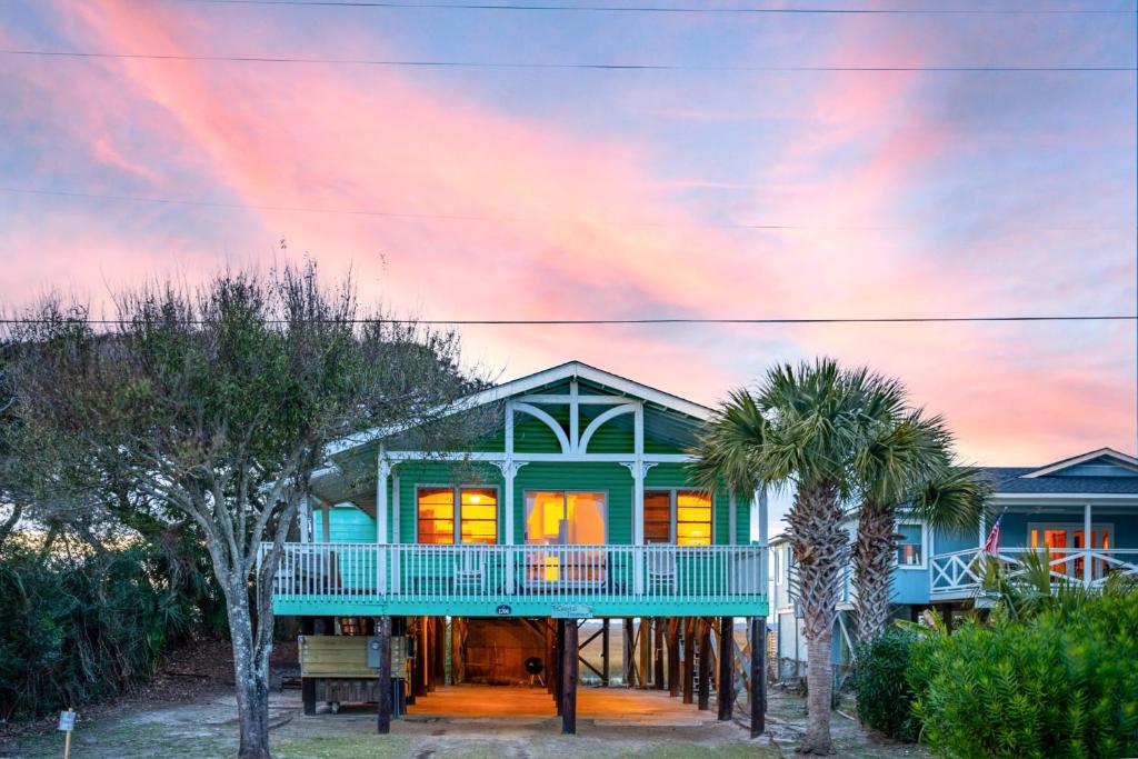 富丽海滩Coastal Treasure的带阳台和棕榈树的蓝色房屋