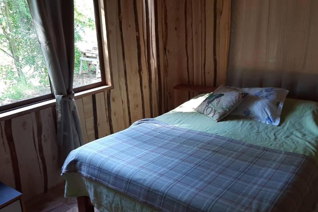 PichareCasa tranquila amueblada的一间卧室配有一张带蓝色棉被的床和窗户。