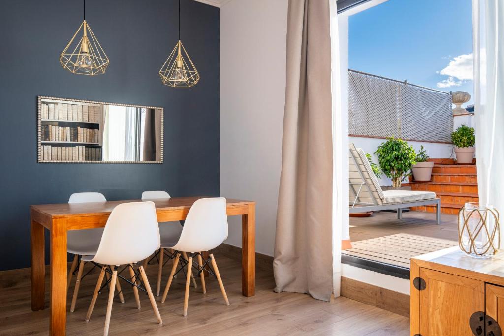 巴塞罗那64号公寓的一间带桌子和白色椅子的用餐室