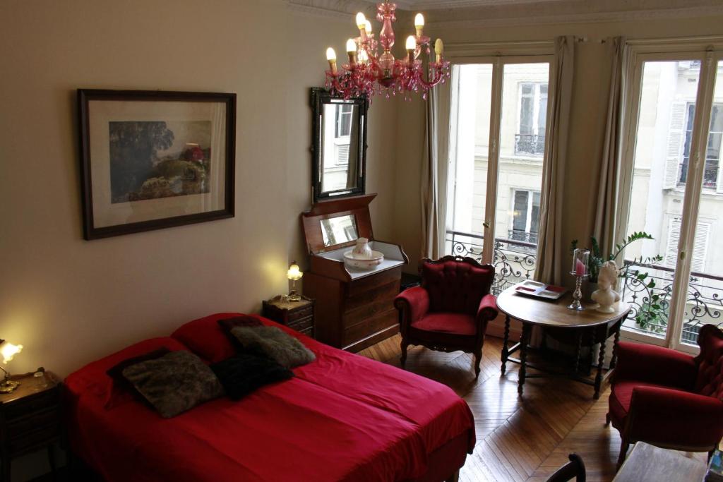 巴黎巴黎一间屋住宿加早餐旅馆的一间卧室配有一张红色的床和吊灯。