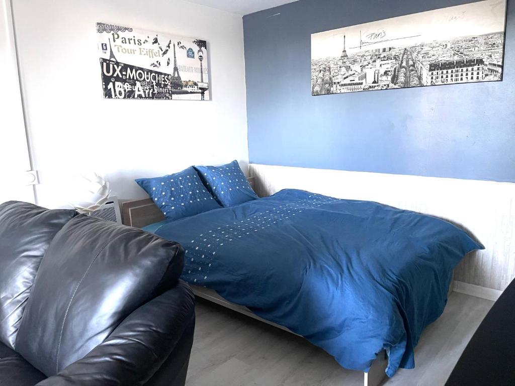 OsnyStudio cosy indépendant avec Jardin à Osny proche Cergy pontoise的一间卧室配有蓝色的床和真皮沙发
