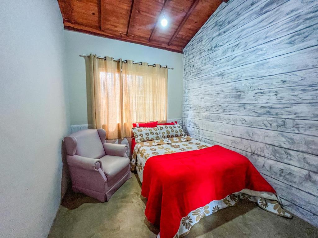 卡兰卡斯Casa Da Cléo Carrancas的一间卧室配有一张床和一把椅子