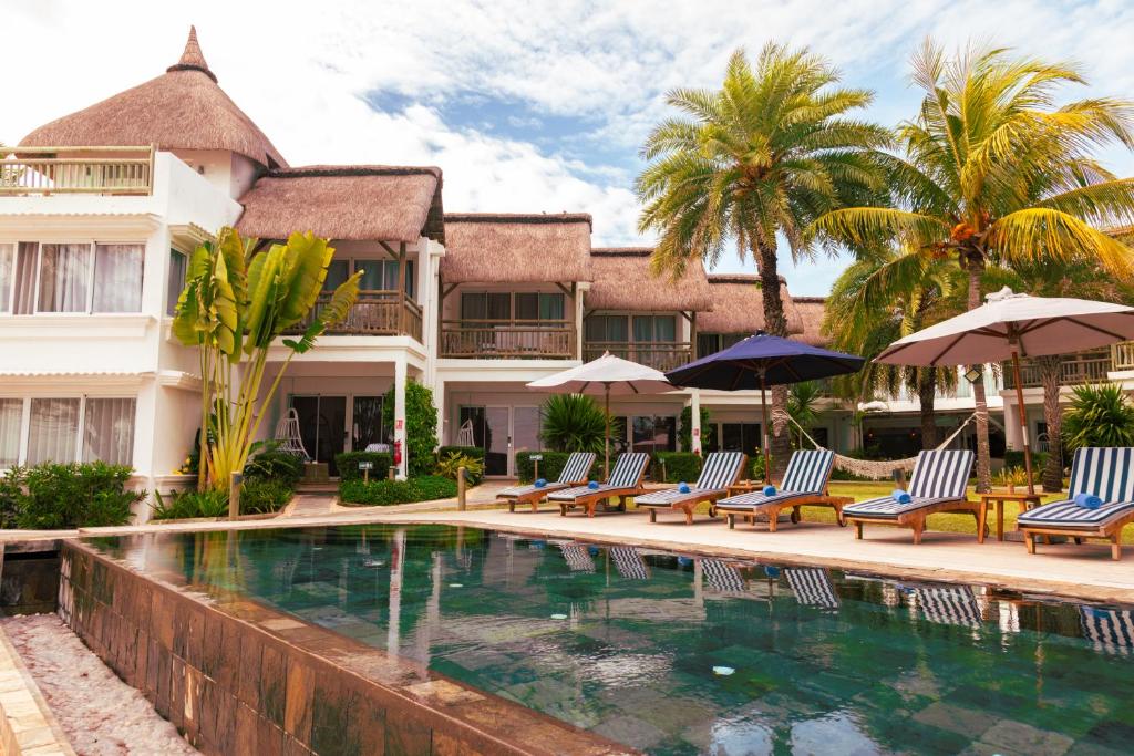 康隆尼角海角精品酒店的一个带椅子和遮阳伞的游泳池的度假酒店